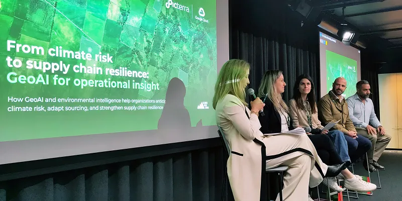 Photo from Climate Week Zurich showing a panel discussion with five speakers seated on stage before Picterra presentation slide on climate risk and supply chain resilience.