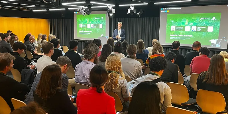 Photo from Climate Week Zurich showing Frank de Morsier presenting on stage in front of slides about climate risk and supply chain resilience, with an audience listening in the foreground.